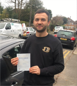 Happy student with certificate after completing automatic driving lessons near Wimbledon with Admire Driving School.